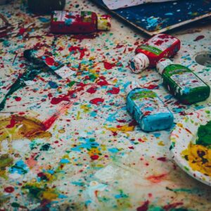 paint spatters and paint bottles strewn about on the ground