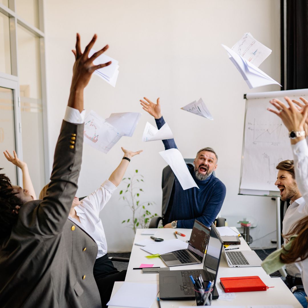 employees throwing papers in air